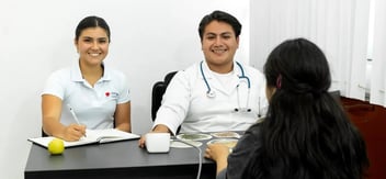Consulta de nutrición y salud en clínica universitaria, con profesionales atendiendo a paciente en un enfoque integral de bienestar.