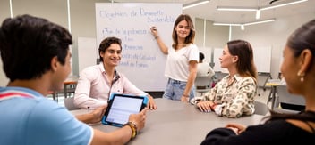 Estudiantes universitarios trabajando en equipo sobre los Objetivos de Desarrollo Sostenible, durante una dinámica colaborativa en aula moderna.